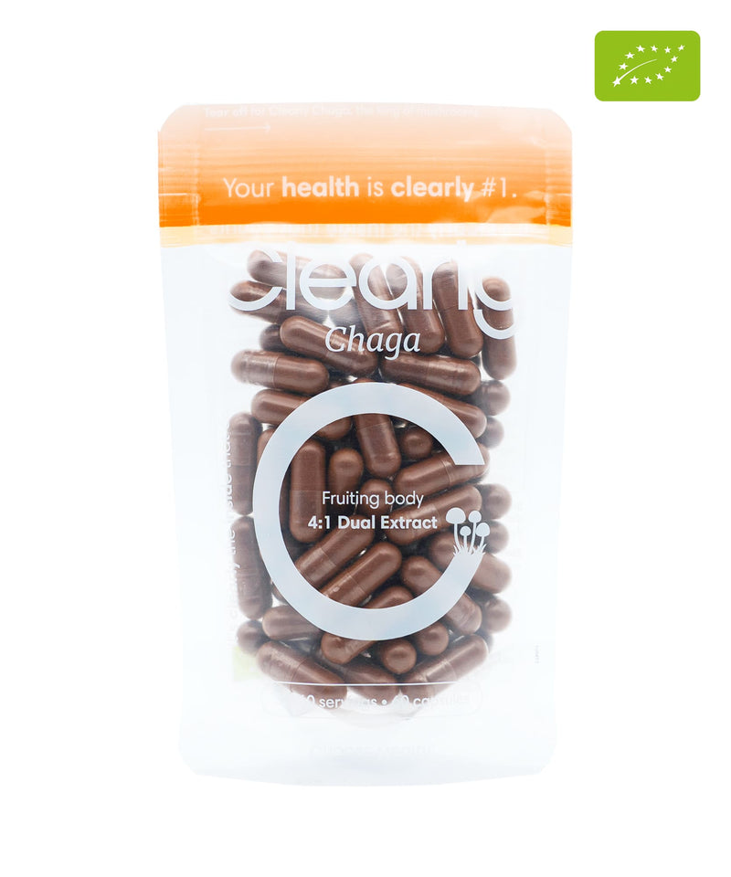 Organic Clearly Chaga capsules, herbal supplement in clear bottle, showing round black Chaga mushroom extract capsules.